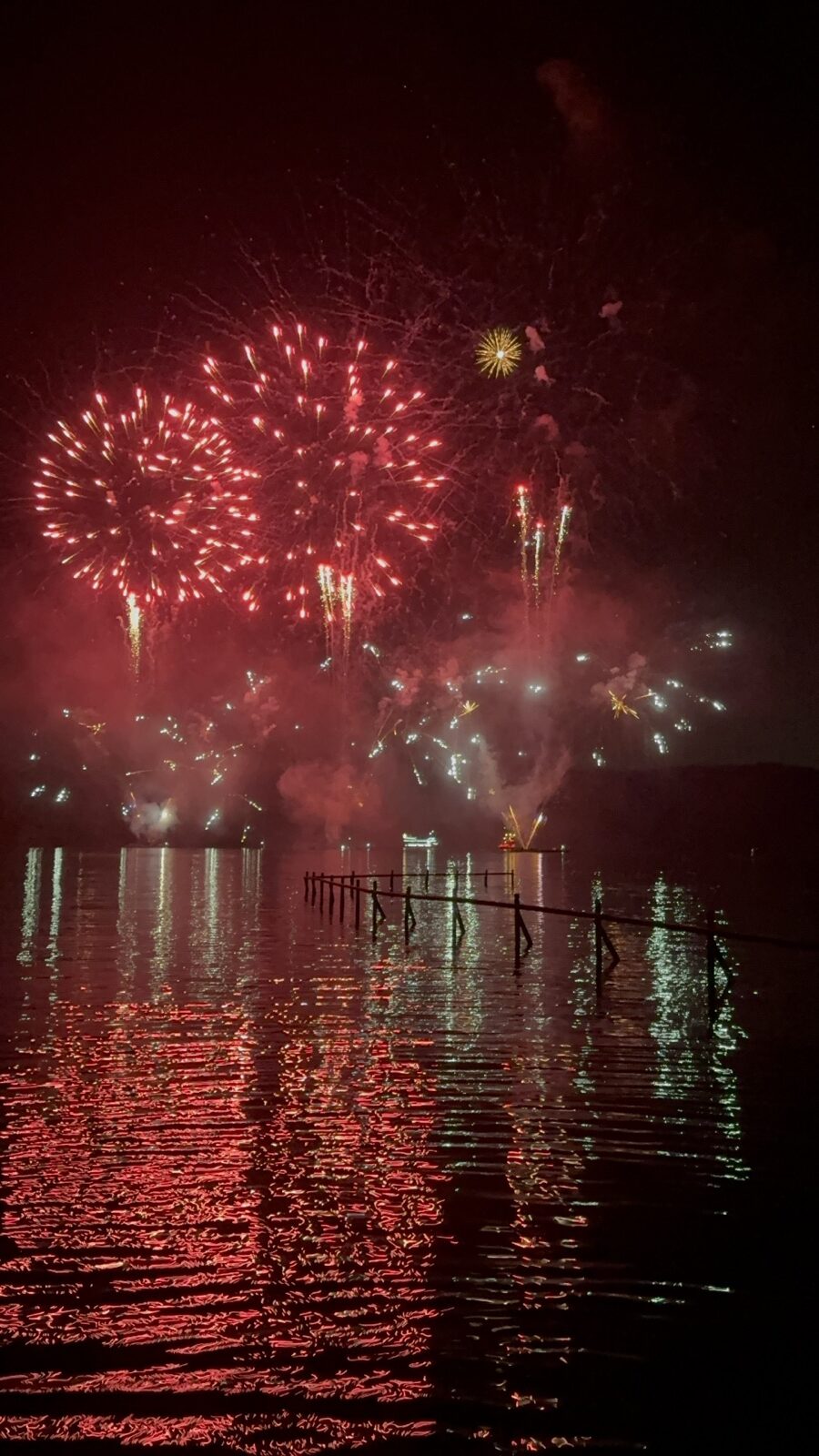 Red fireworks reflected on Lake Ashi during the Hakone summer festival